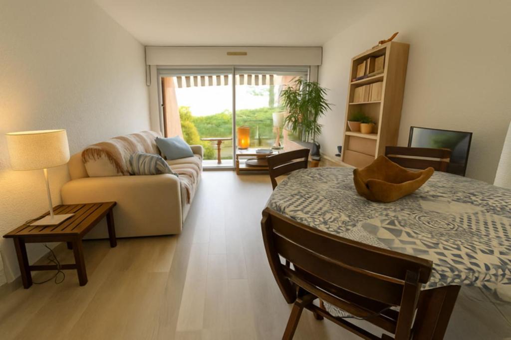 a living room with a table and a couch at Apartment for 6 with garden near beach in Bandol