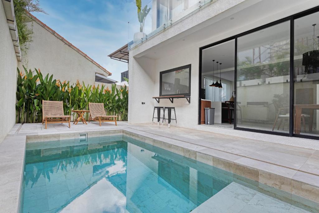 a swimming pool in the backyard of a house at Stark villas - modern villa with roof top in Uluwatu