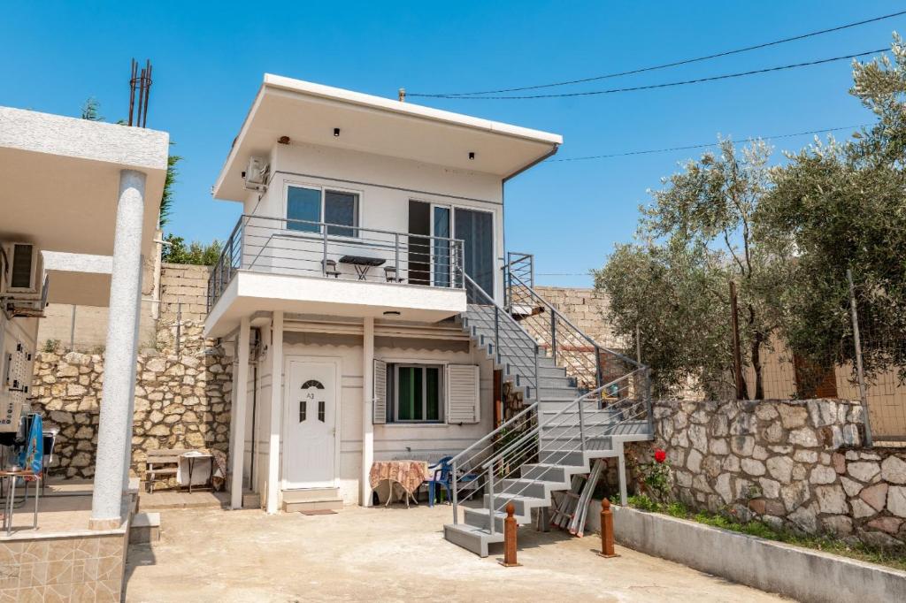 a white house with a staircase in front of it at Vila Celi in Sarandë
