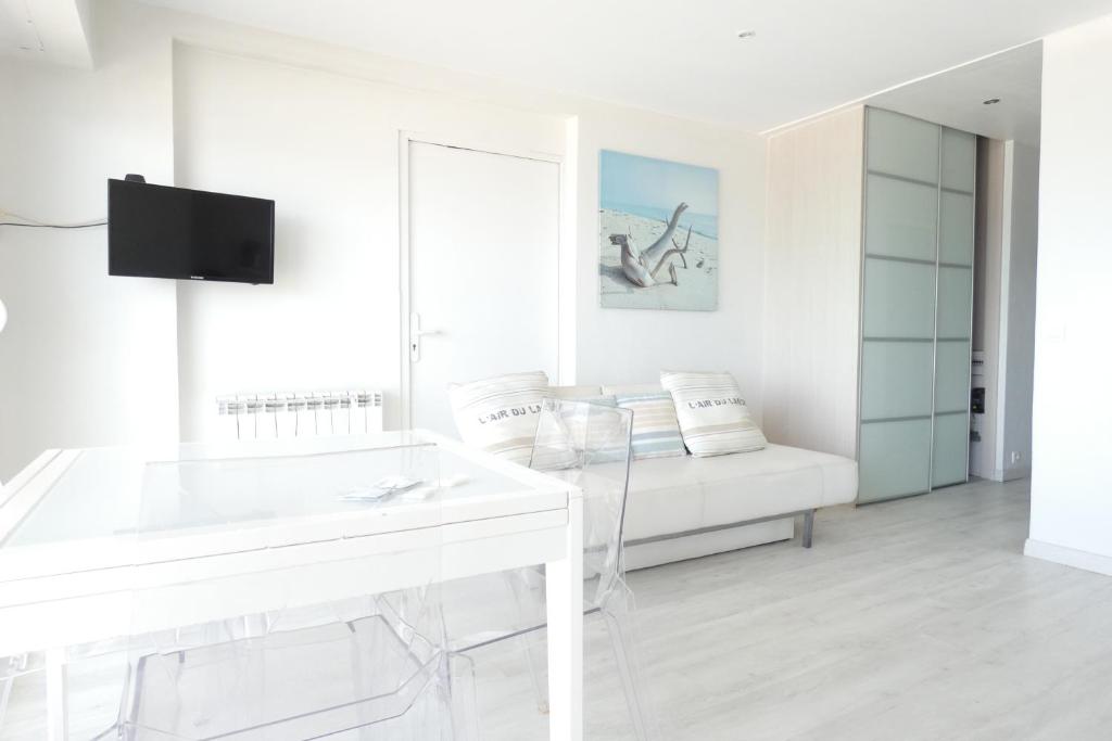 - une salle de bains blanche avec lavabo et canapé dans l'établissement OCEAN BLEU - front de mer et balcon, à La Baule