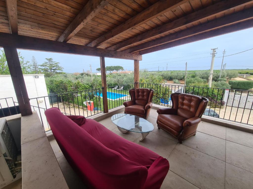 sala de estar con 2 sillas y mesa en el balcón en Casa Vacanza da zio Minguccio, en Castellaneta Marina