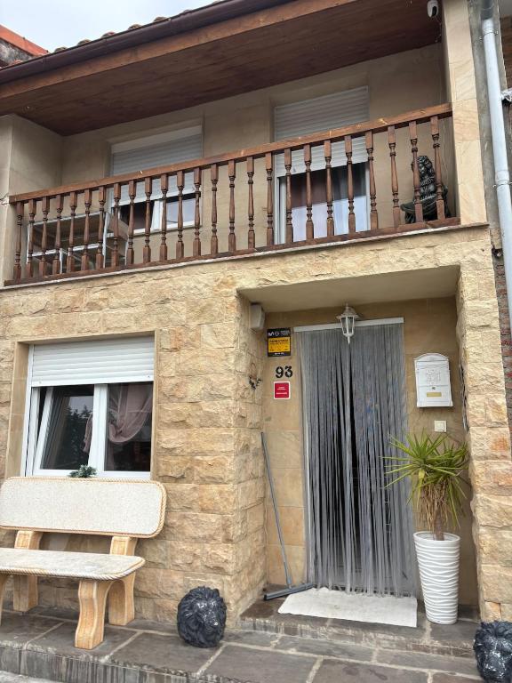 a building with a balcony and a bench in front of it at La pulga en el océano in Torrelavega