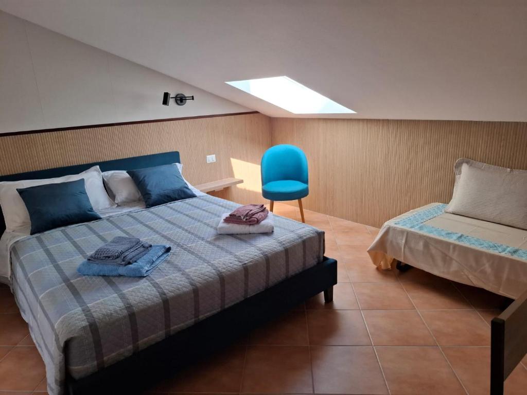 ポルト・トッレスにあるCentro mare residence affitta alloggiのベッドルーム1室(ベッド1台、青い椅子付)