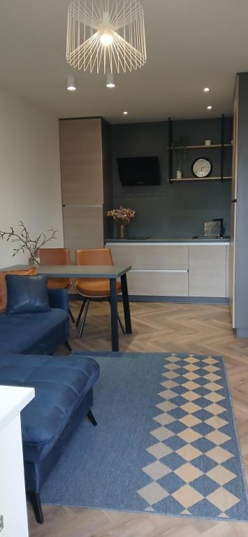 a living room with a blue couch and a table at Alanga in Palanga