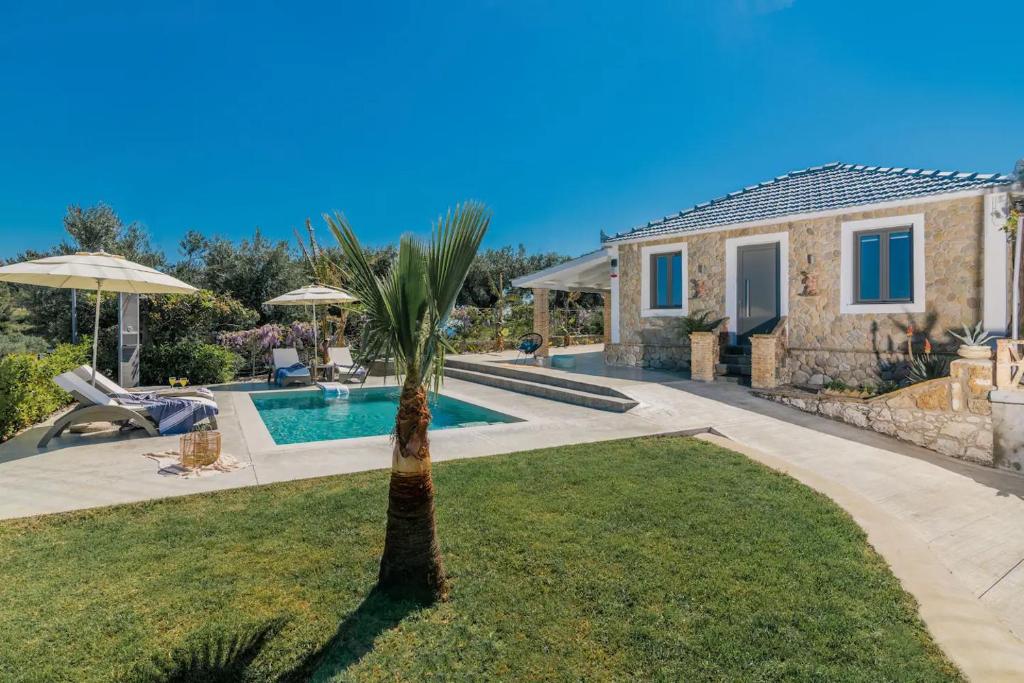 eine Villa mit einer Palme und einem Pool in der Unterkunft Binios Villa - private pool, walking distance from the Beach in Vasilikos