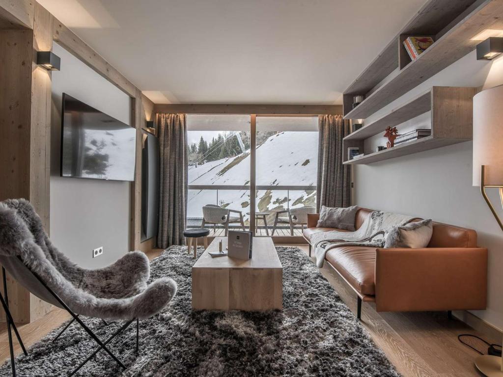 un soggiorno con un divano e un tavolo di Superbe appart 96m² - 8 pers - Centre station - Proche pistes - SPA, Wifi, Parking - FR-1-631-206 a Courchevel