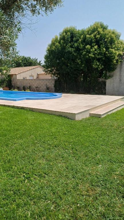 une grande piscine dans une cour avec de l'herbe verte dans l'établissement VILLA KAPETANAKIS, à Redessan