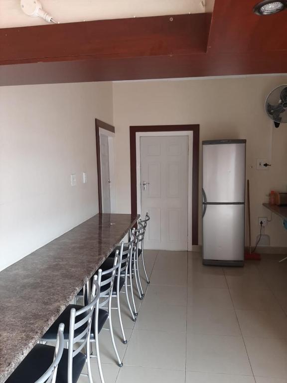 a kitchen with a counter with chairs and a refrigerator at Faraaz BnB in Ladysmith
