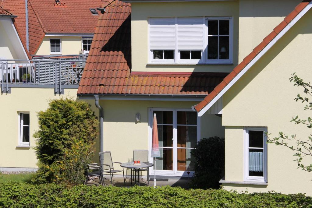 a patio with a table and chairs in front of a house at An der Schmiedestraße Strandläufer in Wustrow