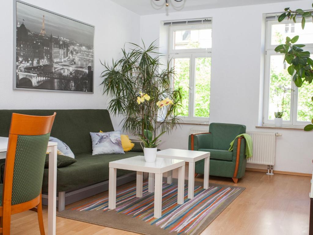 sala de estar con sofá, mesa y sillas en Ferienwohnung Leipzig Nord-Ost, en Leipzig