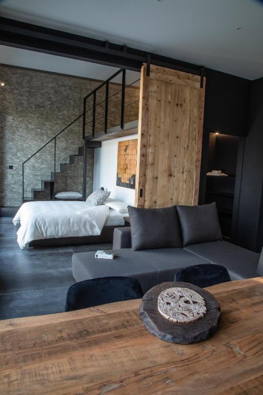 a living room with a couch and a bed at Porta Bormina Loft&Suites in Tirano