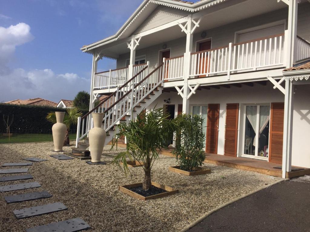 une maison avec un escalier et des plantes devant elle dans l'établissement Villa carioca, à Gujan-Mestras