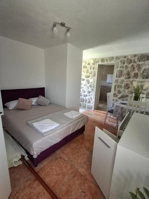 een slaapkamer met een bed, een tafel en stoelen bij Anastasija in Merdari