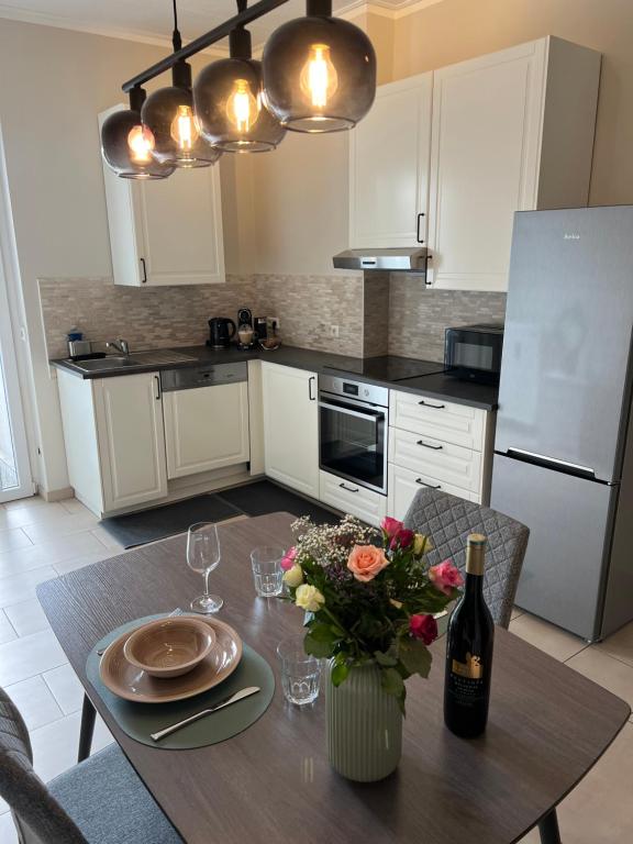 eine Küche mit einem Tisch mit einer Flasche Wein und Blumen in der Unterkunft Ruhrperle Apartment 1 Essen in Essen