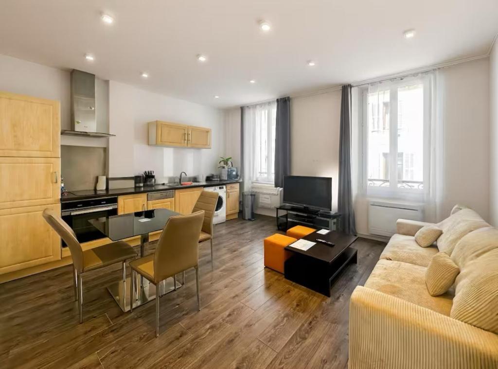 un salon avec un canapé et une table et une cuisine dans l'établissement CANNES - à 50m des plages et de la Croisette, à Cannes