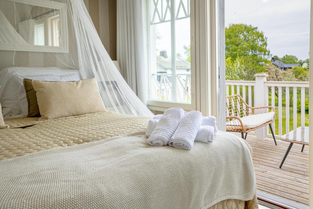 een slaapkamer met een bed met twee handdoeken erop bij Villa Ankkuri in Hanko