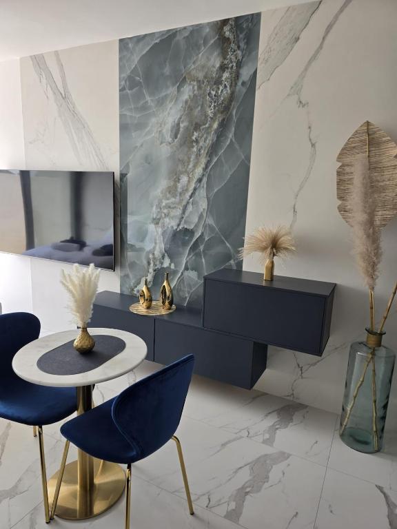 Cette chambre comprend une table, deux chaises et un miroir. dans l'établissement Oasis Dubai Piscine Arena P Expo, à Pérols