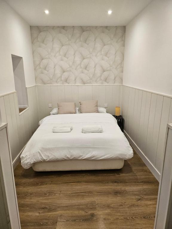Un dormitorio con una cama grande con sábanas blancas. en Hogar en Lavapies 11, en Madrid