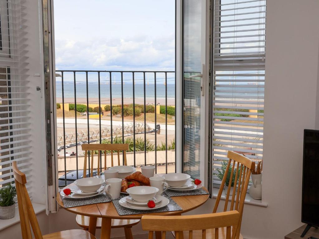 a dining room table with a view of the ocean at Glenholme Apartment 3 in Redcar