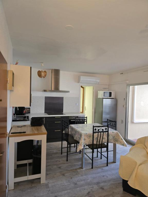 ル・バルカレスにあるCoquet T 2 Le barcares Merのテーブルと椅子のあるキッチンとリビングルーム