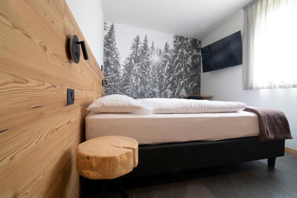 - une chambre avec un lit et un mur en bois dans l'établissement Casa Montana, à Commezzadura