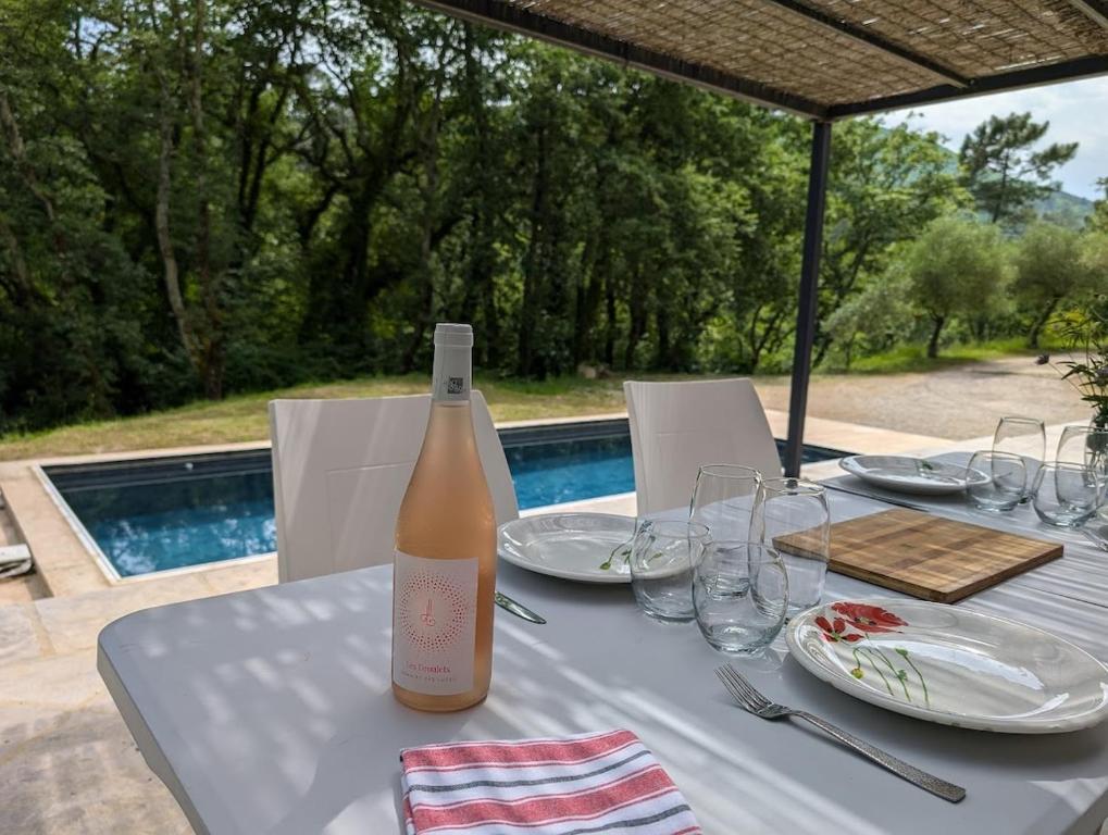 une bouteille de vin posée sur une table avec des verres dans l'établissement Villa Piscine et Nature Cévenole, à Molières-sur-Cèze