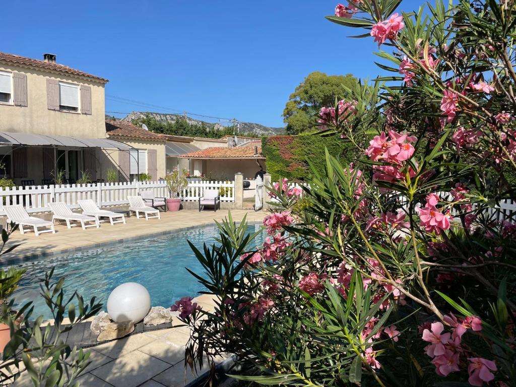 une maison avec une piscine ornée de fleurs roses dans l'établissement Villa de caractères,piscine, vue sur le luberon,3 chambres, à Cheval-Blanc