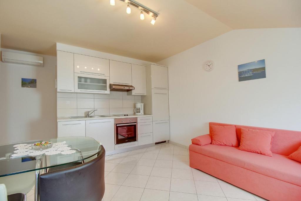 a living room with a red couch and a table at Apartment Jasna Near Čikat Bay and Center with Private Parking in Mali Lošinj