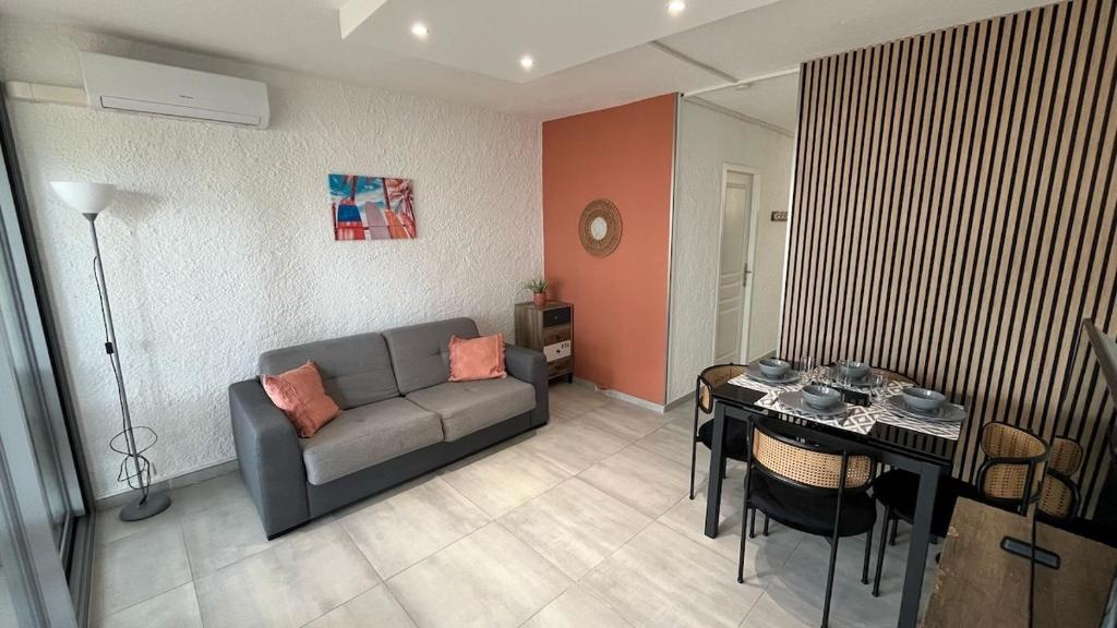 ein Wohnzimmer mit Sofa und Tisch in der Unterkunft studio cabine climatisé proche de la plage in Argelès-sur-Mer