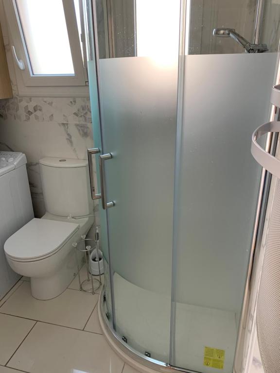 une salle de bain avec toilettes et douche en verre dans l'établissement Appartement La Faute sur mer proche plage RDC, à L'Aiguillon-la-Presqu'île