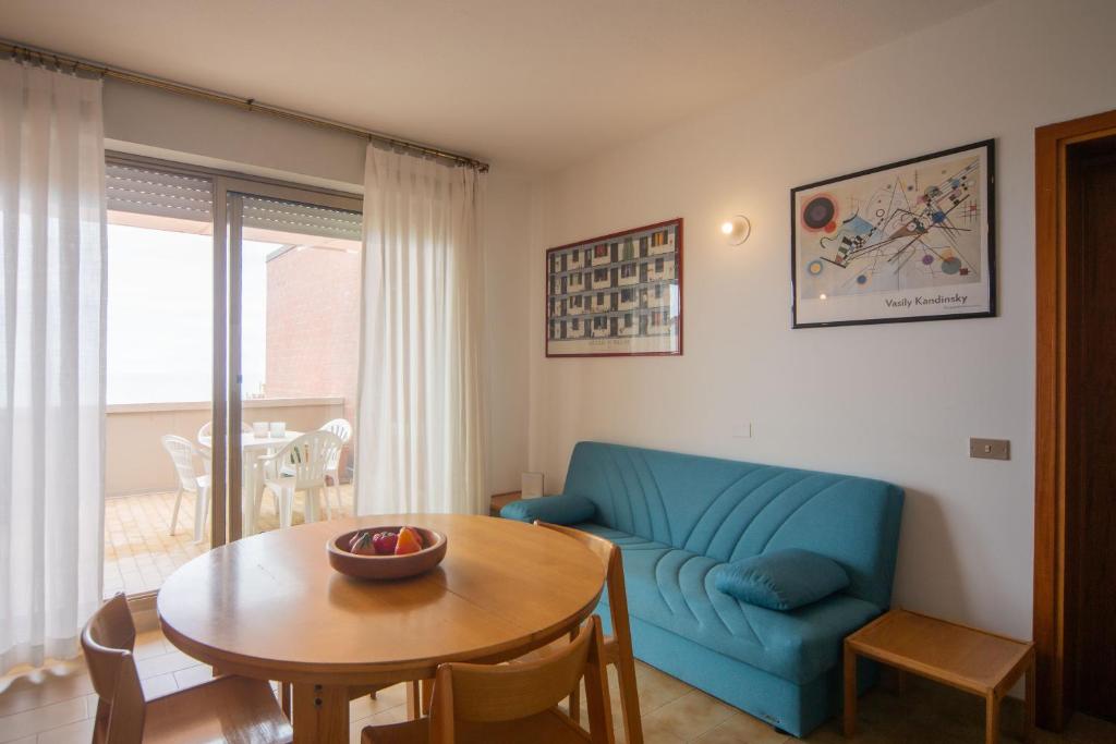 a living room with a blue couch and a table at Casa Elena - Vista Mare e Parcheggio in San Vincenzo