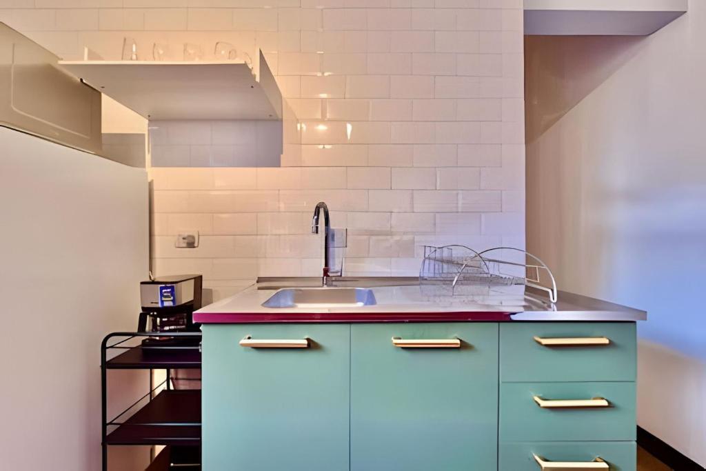 a kitchen with blue cabinets and a sink at KiTNETcompleta ótima localização in Curitiba