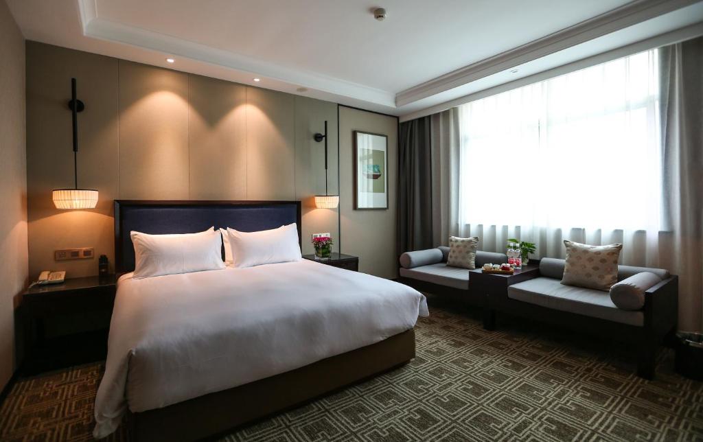 Postel nebo postele na pokoji v ubytování Yiwu Kasion Purey Hotel