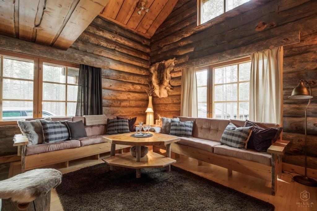 una sala de estar con un sofá y una mesa en Villa Kelo by Hilla Villas, en Kittilä
