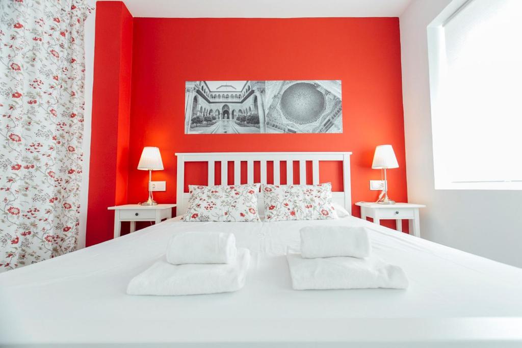 sypialnia z białym łóżkiem i czerwonymi ścianami w obiekcie Colorful and diaphanous- 3Bd 1Bth - Peral w Sewilli
