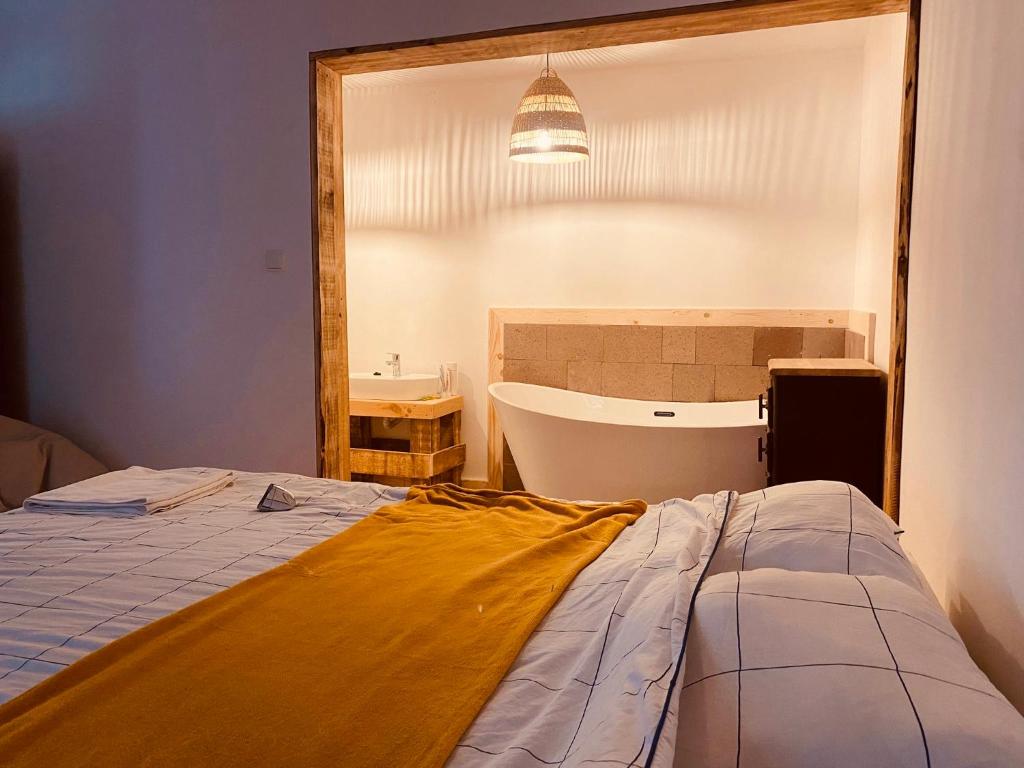 een kamer met een bed, een bad en een spiegel bij Menasagi Sit & Dream Cottage 2 in Menasag-Ujfalu