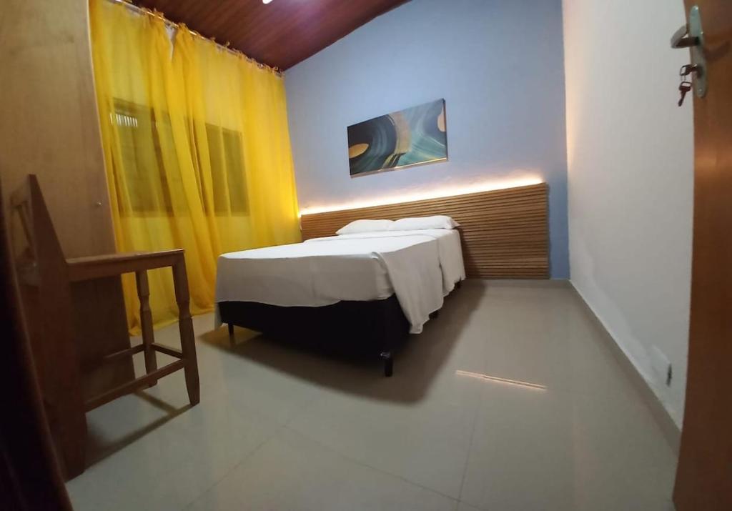 a bedroom with a bed and a yellow and blue wall at 01 Lindo apartamento na praia com piscina in São Sebastião