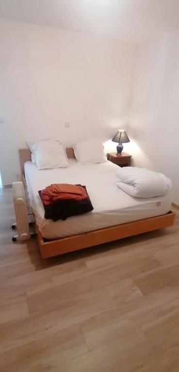 - une chambre avec un grand lit et une lampe dans l'établissement Chambre parquet flottant chez l'habitant, à Saint-Corneille
