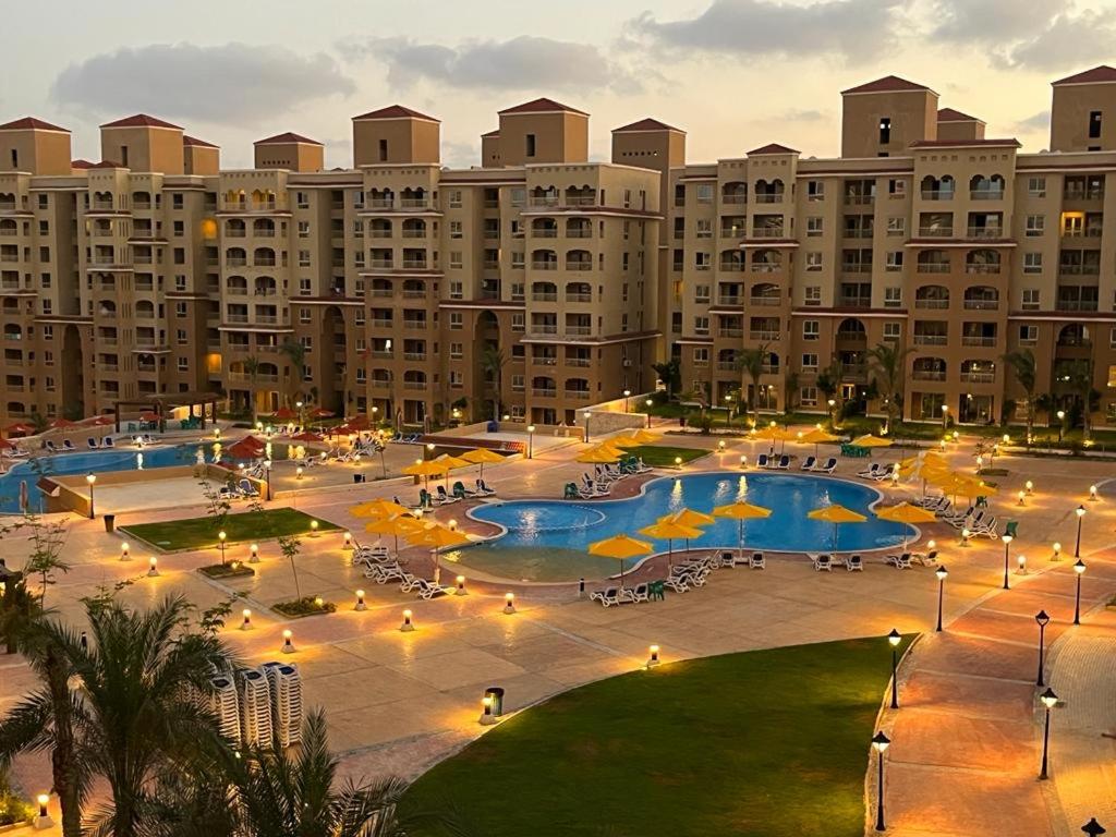 a large building with two pools with umbrellas at AQUA View resort in El Alamein