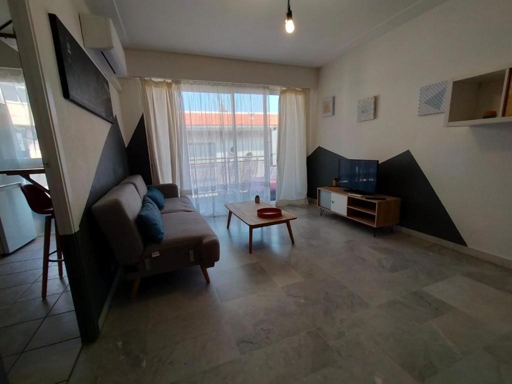 un salon avec un canapé et une table dans l'établissement Grand studio , proche port Bastia, à Bastia