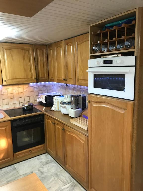 a kitchen with wooden cabinets and a stove top oven at Villa Ikaros Ag Apostoloi Attica in Mesochórion