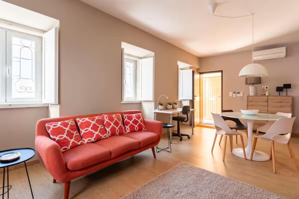 un soggiorno con divano rosso e una sala da pranzo di Tower of Belém Premium Apartments A, B & C a Lisbona