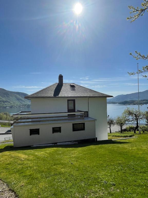 a white house with the sun in the sky at Retro hus med fin beliggenhet in Haddal