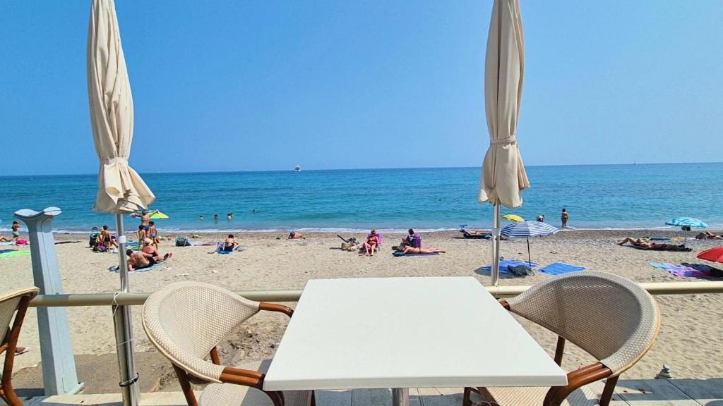 - une table et des chaises sur une plage donnant sur l'océan dans l'établissement Casa GAIA, à Menton