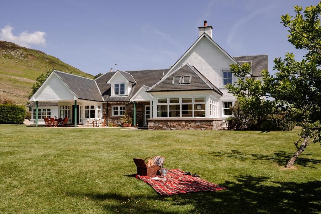 a house with a picnic blanket on the lawn at Deanshaugh - Seasgair Lodges in Deanshaugh
