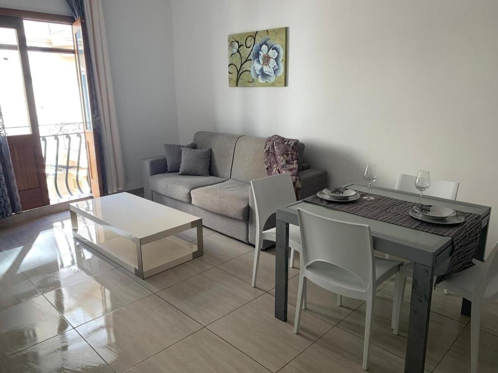 una sala de estar con una mesa y un sofá en Spacious Apartment in Downtown City, en Il-Gżira