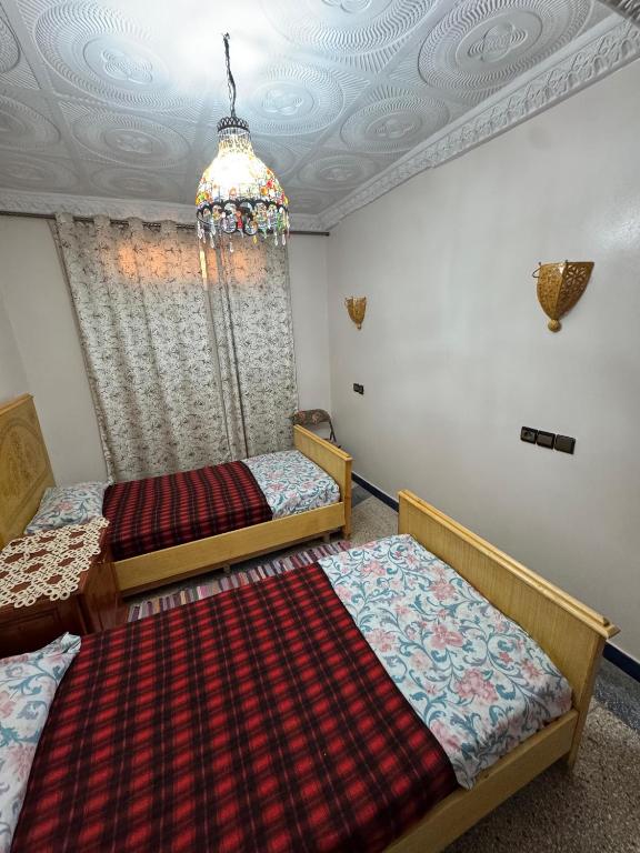 two beds in a room with a ceiling at Appartement Atlas, Rue Mouatamid Ibn Abbad, Immeuble Malki, 1er étage, Oujda in Oujda