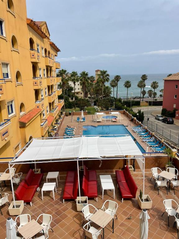 贝纳尔马德纳Hotel ViveMar的一座带躺椅的游泳池和一座建筑