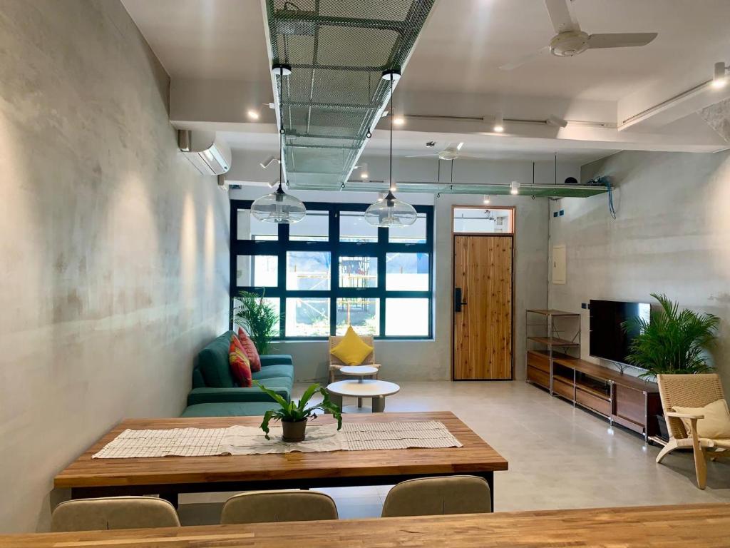 a living room with a table and a couch at The Moment Hostel Dulan in Donghe