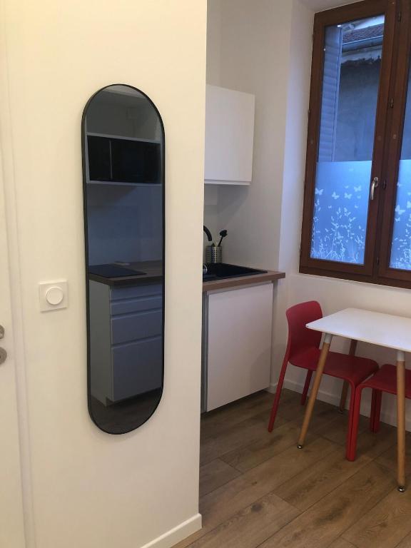 - un miroir mural dans la cuisine avec une table dans l'établissement La Tronche studio climatisé wifi proche CHU, à La Tronche